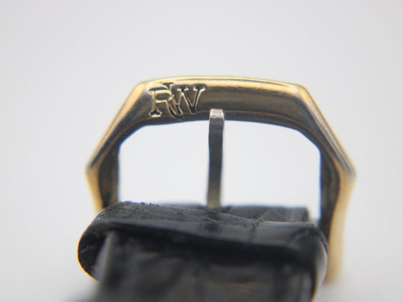 Close-up of the gold-tone buckle, clearly displaying the engraved 'RW' logo.