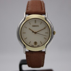 Reloj vintage Gucci 8000.2.M de cuarzo suizo con caja bicolor, esfera color crema e indicador de fecha.