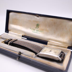 Vintage blue watch box by Perry Greaves Birmingham, with the PRONTO watch nestled inside on a white background.
