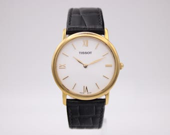 Vintage Tissot C276K goudkleurig kwartshorloge met witte Romeinse wijzerplaat en zwarte leren band, slanke dresswatch, jaren 1990 swiss made