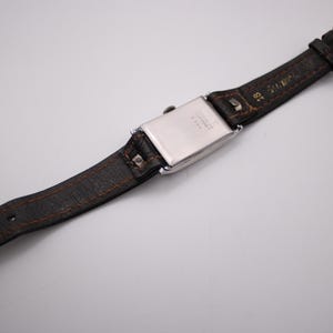 View from the back of the watch and strap, showing the strap construction, 18mm lug width, and gold-tone pin buckle.