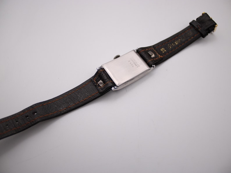 View from the back of the watch and strap, showing the strap construction, 18mm lug width, and gold-tone pin buckle.