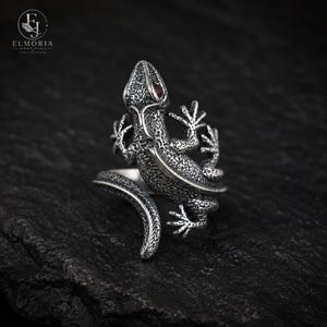 Side profile of an adjustable lizard ring crafted from 925 sterling silver. Detailed wrap-around gecko design creates a bold gothic statement while providing a comfortable and versatile fit.