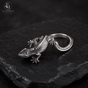 Sterling silver gecko ring with detailed 3D sculptural design and red gemstone-style eyes. Gothic punk jewelry inspired by wildlife and nature, ideal for men and women who love alternative fashion.