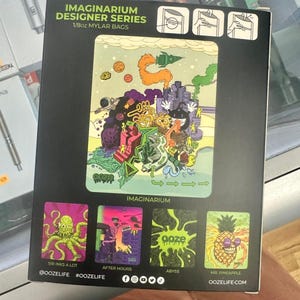 May include: A black box featuring "IMAGINARIUM DESIGNER SERIES 1/8oz MYLAR BAGS" with colorful illustrations. The main image is a whimsical scene with a rocket ship, planets, and buildings. Smaller images include an octopus, a monster, and a pineapple.