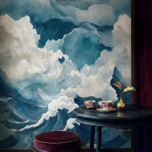 May include: A large wall art piece depicting a stylized ocean scene with swirling blue and white waves. A small, round table holds two teacups with floral designs. A small, gold vase with gold leaves sits on the table.