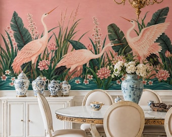 May include: A dining room featuring a wall mural with pink birds and green foliage, a white sideboard with blue and white porcelain jars, a round marble table, and upholstered chairs. A gold chandelier hangs above the table.