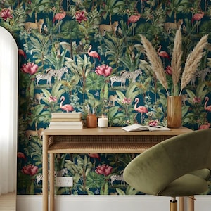 May include: A teal wallpaper with a jungle theme featuring zebras, leopards, flamingos, and lush foliage. A wooden desk with a green chair, a vase with pampas grass, a candle, and books are in front of the wallpaper.