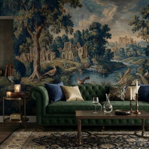 May include: A living room featuring a green tufted sofa with blue and gold pillows, a dark wood coffee table, and a detailed landscape tapestry on the wall. The tapestry depicts a river, ruins, and trees.