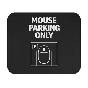 May include: A white ceramic mug with a black handle and the text "But First, Coffee" in a bold, black font. The mug is set against a blurred background, suggesting a cosy setting.