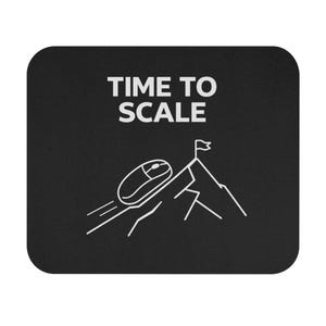 Op de afbeelding: Zwarte muismat met afgeronde hoeken. De witte tekst "TIME TO SCALE" staat bovenaan. Een witte afbeelding toont een computermuis die een berg beklimt met een vlag op de top.