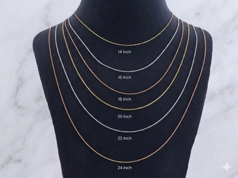 May include: A display of six delicate chain necklaces in gold, silver, and rose gold tones, each with a different length. The lengths are labeled: 35.5 cm, 40.6 cm, 45.7 cm, 50.8 cm, 55.9 cm, and 61 cm.