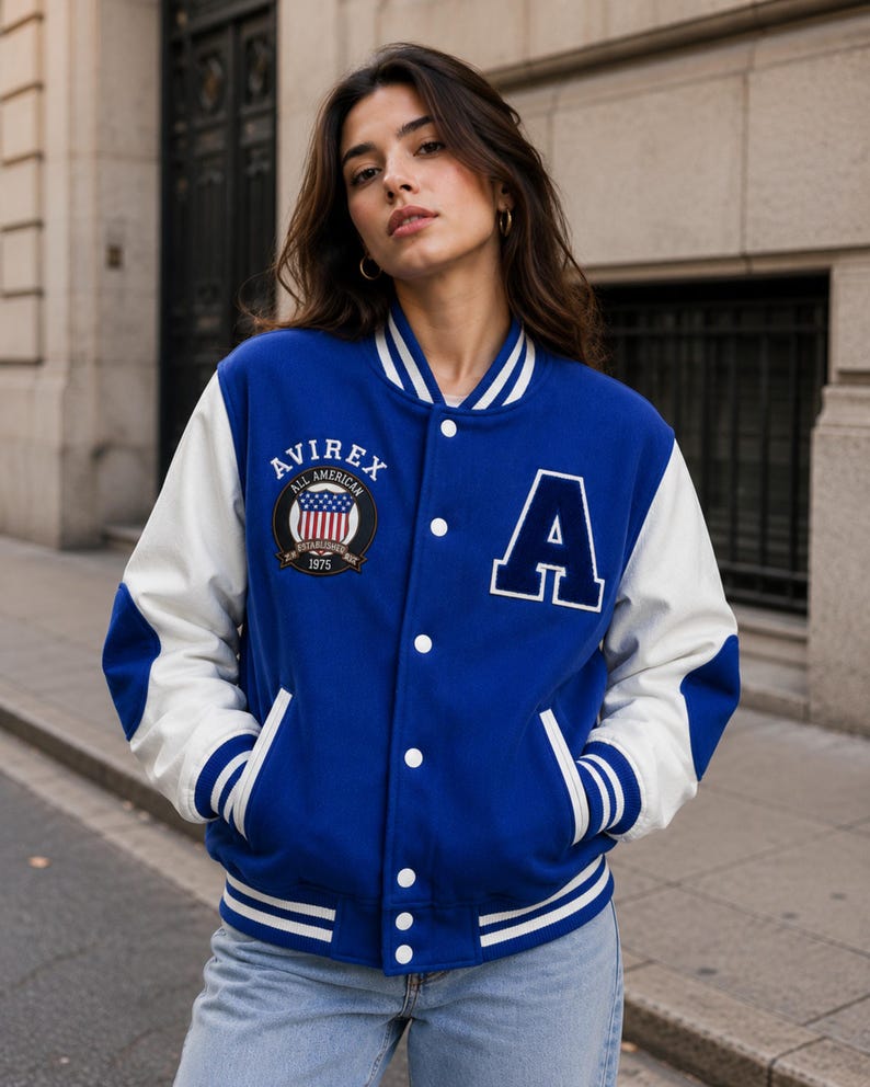 Female model styling premium blue varsity bomber jacket with white sleeves and street fashion look”