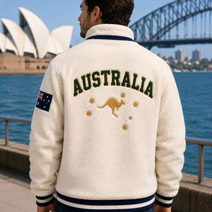 Men's Australia Sherpa Fleece Jacket back view featuring large AUSTRALIA embroidery, kangaroo graphic, Southern Cross stars, Australian flag sleeve patch, cream Sherpa fleece, Sydney Harbor backdrop.
