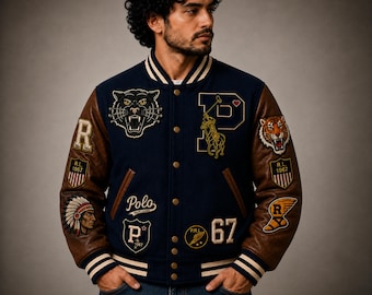 Könnte beinhalten: Eine marineblaue Collegejacke mit braunen Lederärmeln, die mit verschiedenen gestickten Aufnähern versehen ist, darunter ein Tigerkopf, ein Polospieler, die Zahl 67 sowie der Schriftzug Polo Ralph Lauren, R.L. 1967 und P. Die Jacke hat gestreifte Bündchen.