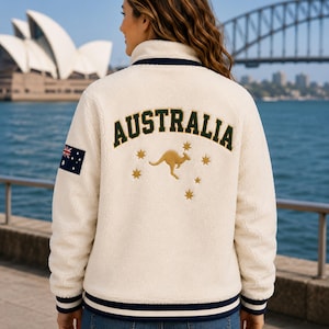 Women's Australia Sherpa Fleece Jacket back view with large AUSTRALIA lettering, kangaroo emblem, Southern Cross stars, cream Sherpa fleece and Australian flag patch on sleeve.