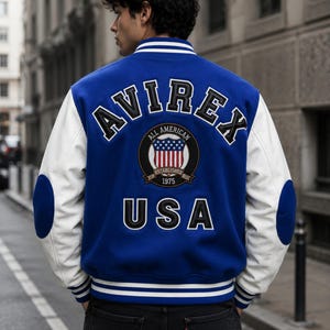 Back view of male model wearing AVIREX inspired varsity jacket with USA embroidery design”