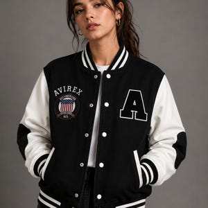 Female model wearing premium black and white varsity jacket front view with oversized fit