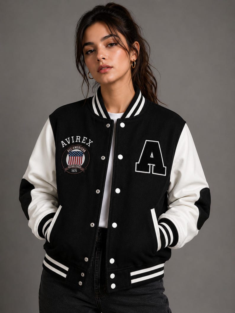 Female model wearing premium black and white varsity jacket front view with oversized fit