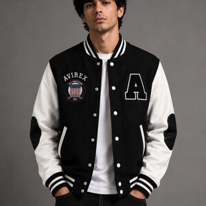 Male model wearing black and white varsity jacket front view in studio style street wear fashion shoo