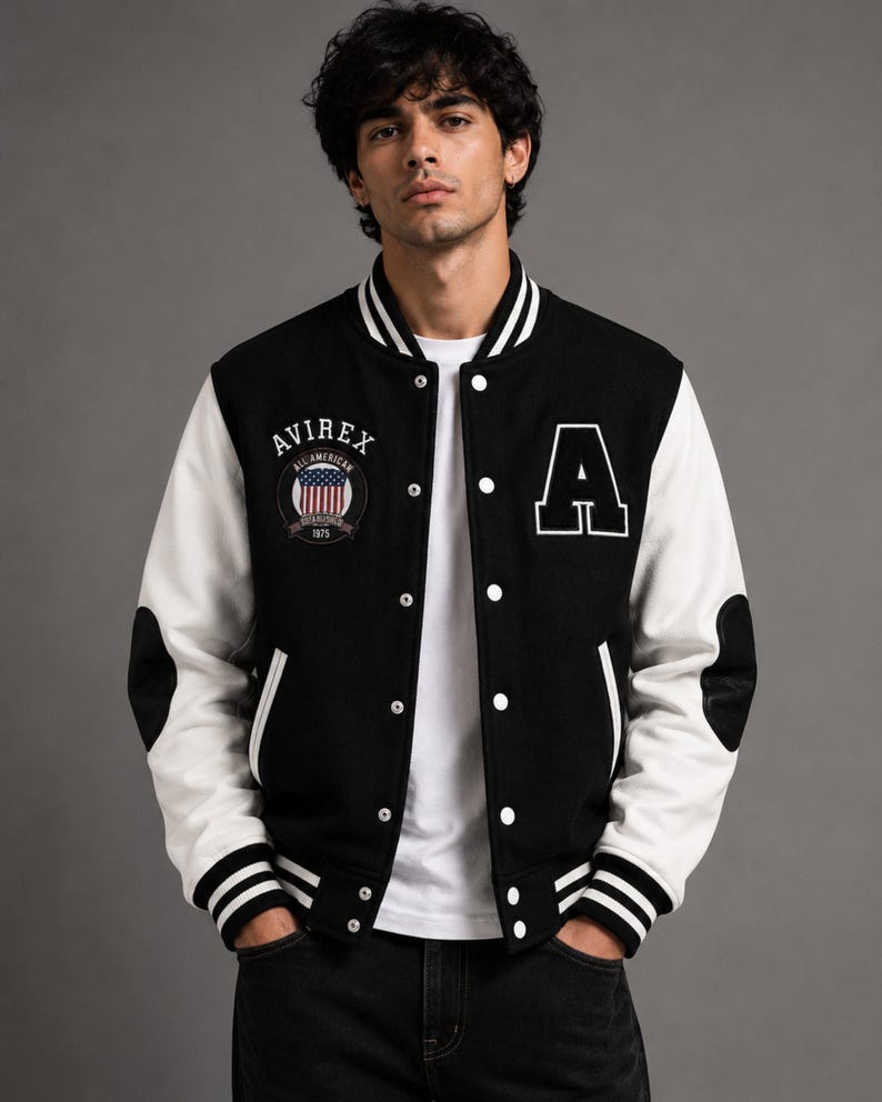 Male model wearing black and white varsity jacket front view in studio style street wear fashion shoo
