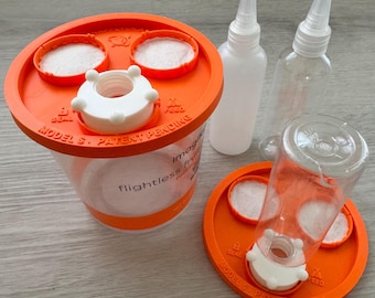 May include: A clear plastic container for flightless fruit flies with an orange lid labeled Model S Patent Pending. The set includes two additional orange lids, two clear plastic squeeze bottles with white caps, and white circular filter pads.