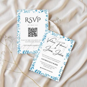 May include: Two white wedding invitation cards with blue floral border designs. One card reads "RSVP" and includes a QR code. The other card displays the names "Victoria Fibonacci & James Jenkins" and wedding details.