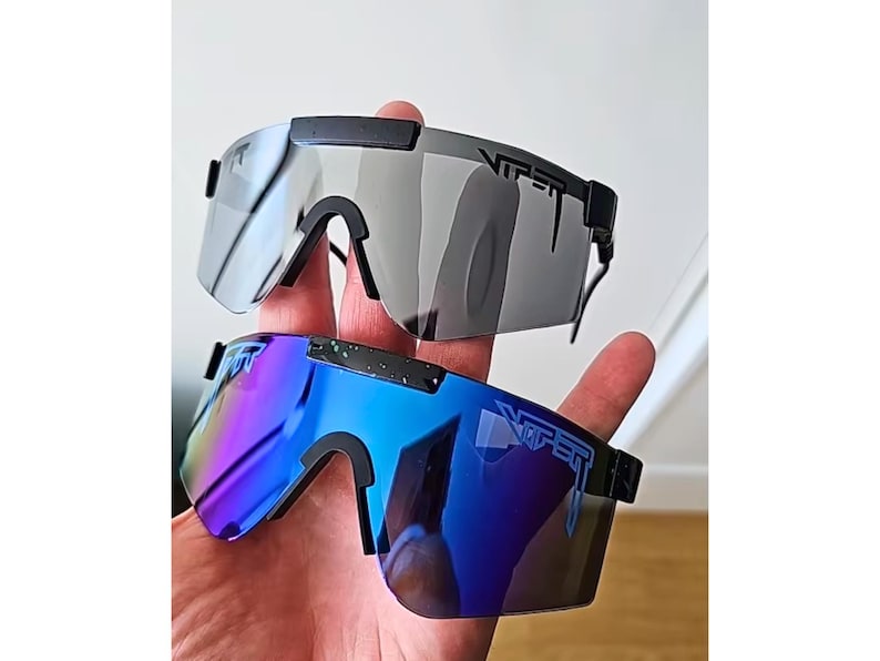 May include: Two pairs of Viper sunglasses. One pair has gray lenses, the other has blue and purple gradient lenses. Both have black frames and the Viper logo on the temples.