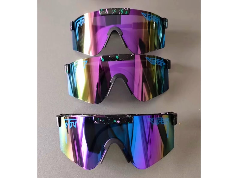 May include: Three pairs of iridescent sunglasses with a black frame and a mirrored lens. The lenses shift in color from purple to blue and yellow. The brand name is printed on the top of the frame in blue.