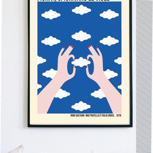 Può includere: Stampa artistica incorniciata con il testo "FIORIVI, SFIORIVANO LE VIOLE" e "RINO GAETANO - MIO FRATELLO È FIGLIO UNICO, 1976". L'opera presenta un cielo blu con forme di nuvole bianche e due mani che tengono una nuvola. Le mani hanno lo smalto rosso.