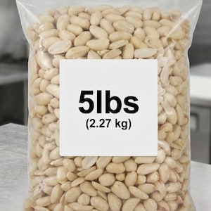 Può includere: Un sacchetto di plastica trasparente pieno di arachidi sgusciate. Un'etichetta bianca sulla borsa mostra il testo "5lbs (2.27 kg)" in nero. Le arachidi sono di colore beige chiaro e riempiono completamente il sacchetto.