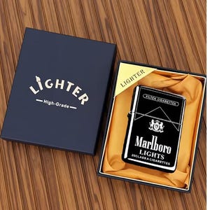 May include: A black and silver Marlboro Lights lighter in a navy blue gift box. The lighter features the Marlboro logo and text. The box is labelled "Lighter" and "High-Grade".