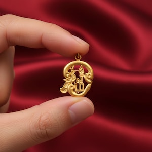 Peut inclure: Un pendentif en métal doré présentant un design ajouré composé d'un oiseau stylisé et d'une forme verticale rappelant une bougie, le tout enfermé dans un cadre circulaire. Le pendentif possède une petite boucle au sommet et une finition mate.