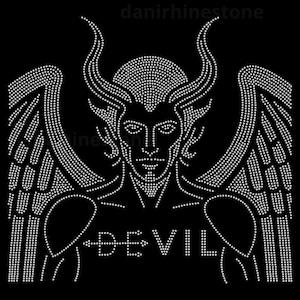 Op de afbeelding: Een strass-transferontwerp op een zwarte achtergrond met een symmetrische afbeelding van een gevleugelde figuur met hoorns. Het woord DEVIL is in witte strass-steentjes over de borst gespeld, met een klein pijlsymbool tussen de letters.