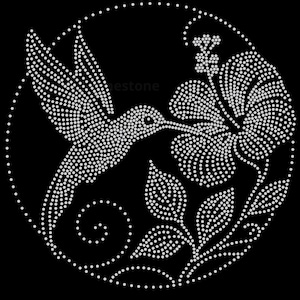 Puede incluir: Un diseño circular compuesto por pedrería blanca sobre un fondo negro, que muestra un colibrí en vuelo acercándose a una gran flor de hibisco con hojas y un elemento de enredadera en espiral, bordeado por un círculo de puntos.
