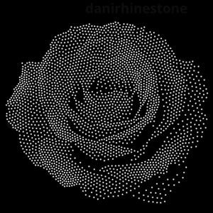 May include: A rose design created with white rhinestones on a black background. The floral pattern is formed by a dense arrangement of individual sparkling stones, creating a detailed silhouette of a blooming rose. The text danirhinestone is visible.