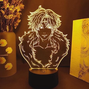 May include: A glowing LED lamp featuring a detailed outline of an anime character with spiky hair and a fur-like collar. The lamp is mounted on a black base, emitting a warm, inviting light. The design is a unique decorative piece.