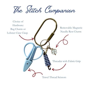 May include: The Stitch Companion set includes a gold-toned oval hardware ring, light blue travel thread scissors, a needle threader with a blue and white gingham fabric grip, and a white four-leaf clover removable magnetic needle rest charm.
