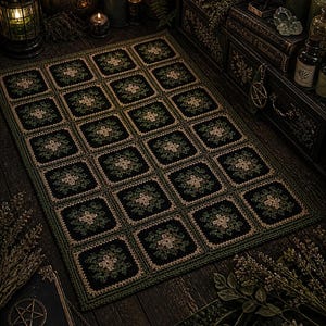 May include: A handcrafted, square crochet rug featuring a repeating pattern of dark green and tan floral motifs on a black background. The rug is bordered with a dark green trim, and is displayed on a dark wooden surface. The rug is a decorative home decor item.