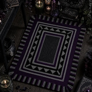 Könnte beinhalten: Ein rechteckiger Teppich in Dunkelviolett und Grau mit geometrischem Muster. Der Teppich hat ein zentrales Quadrat, das von grauen, schwarzen und violetten Bordüren umgeben ist, mit einem Fransenrand. Der Teppich liegt auf einem Holzboden, mit Kerzen und Büchern im Hintergrund.