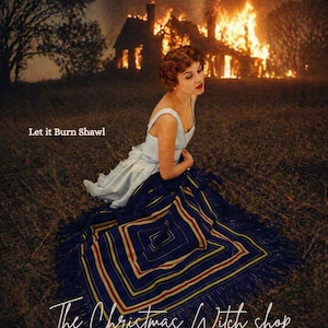 Puede incluir: Una mujer con un vestido azul claro está sentada sobre un chal azul oscuro con un patrón geométrico y flecos. Detrás de ella, una casa está en llamas. El texto en la imagen dice "Let it Burn Shawl" y "The Christmas Witch shop".