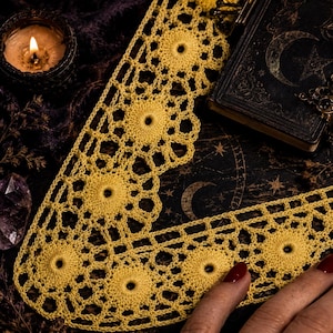 May include: A bright yellow crochet lace collar featuring a repeating circular motif pattern with an openwork design. The lace is constructed with fine thread, showcasing a delicate, interconnected geometric structure throughout the entire piece.