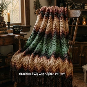 Può includere: Un afgano all'uncinetto a zig-zag nei toni del marrone, verde e beige è drappeggiato su una sedia di legno. L'afgano ha un bordo con frange e il testo "Crocheted Zig Zag Afghan Pattern" è visibile. The Christmas Witch shop.