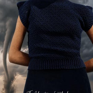 May include: A navy blue crochet top with short sleeves and a ribbed hem. The top is paired with a matching skirt. The image includes the text "The Christmas Witch shop" and "Crochet Patterns & Spooky Vibes". A tornado is in the background.