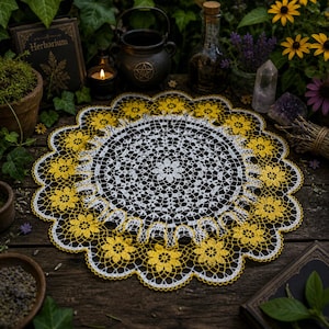May include: A handmade, round doily with a floral design. The center is white, surrounded by a yellow floral border. The doily is placed on a dark wooden surface, with other mystical items in the background.