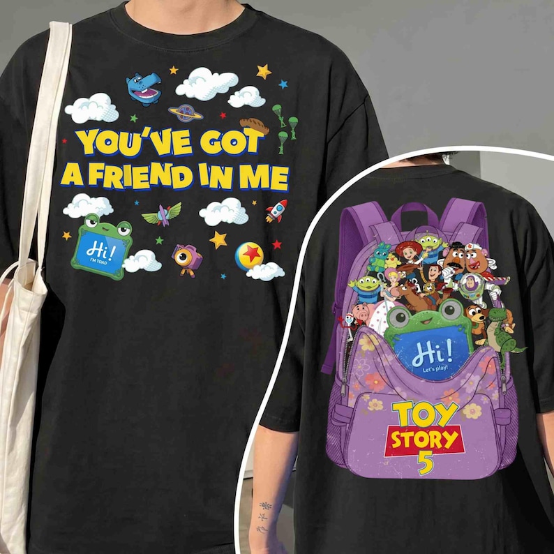 Pode incluir: Uma t-shirt preta com o texto amarelo YOU'VE GOT A FRIEND IN ME e gr&aacute;ficos coloridos de nuvens, estrelas e personagens. O design das costas apresenta uma mochila roxa cheia de v&aacute;rios personagens animados e o texto TOY STORY 5.