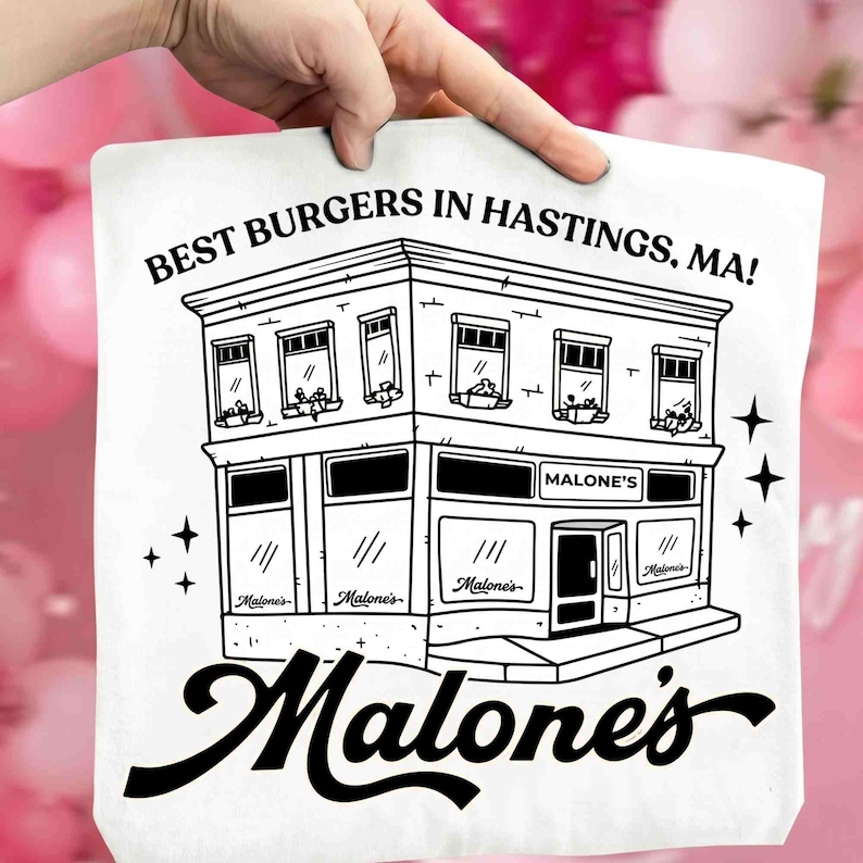 May include: A white tote bag featuring a black and white illustration of a two-story building with the text "BEST BURGERS IN HASTINGS, MA!" and "Malone's" in a stylized font. The design includes stars.