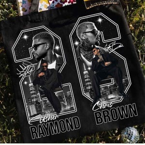 May include: A black tote bag featuring a graphic print of two large white outlines of the number 22. Inside the outlines are black and white portraits of Usher and Chris Brown, city skylines, and their printed names and signatures in white.