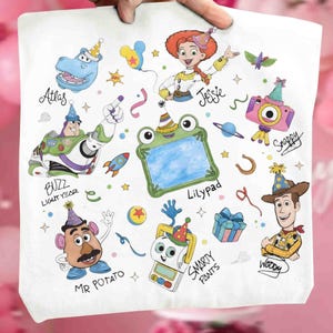 May include: A white fabric surface featuring colorful cartoon illustrations of characters including Buzz Lightyear, Jessie, Woody, Mr. Potato Head, and a frog-shaped frame labeled Lilypad, along with party-themed icons and text labels.