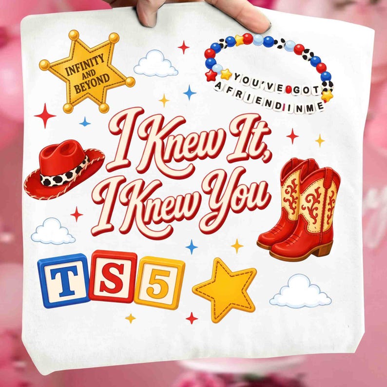 May include: A white tote bag featuring a graphic print with the text I KNEW IT, I KNEW YOU. The design includes a yellow sheriff star with INFINITY AND BEYOND, a beaded bracelet with YOU'VE GOT A FRIEND IN ME, a red cowboy hat, red boots, and blocks with TS5.